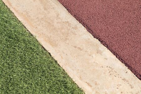 Rubber playpark flooring, red rubber wetpour next to concrete and green artificial grassの写真素材