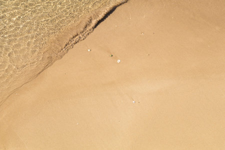 Beautiful crystal clear sea water, Gentle waves breaking on golden sand beach.  From above with copy space.の写真素材