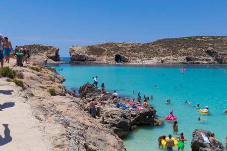 Tourists enjoying beautiful crystal clear azure turquoise blue waters of the Blue Lagoon on the small holiday island of Comino, Malta, June 2017のeditorial素材