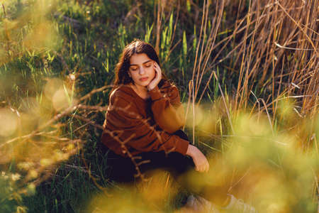 Portrait of beautiful young woman in the sun flare with flowersの写真素材