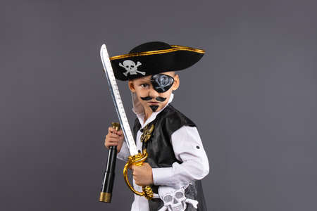 Classic captain pirate with face painted lunging forward with raised sword in challenging pose. Isolated on gray background with plenty of room for copy. Happy Halloweenの写真素材