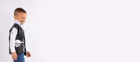Banner, long format. A cute, smiling boy in a pirate costume with a painted mustache and a beard. Looks to the side when he sees something funny. Photo on white background with large blank space. High quality photoの写真素材