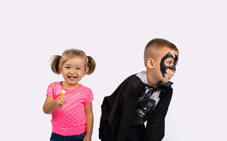 Happy kids at halloween party with happy smile and lollipops. Cute boy and girl on white background. High quality photoの写真素材