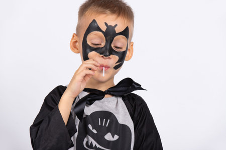 Funny child with lollipop, happy little boy eating lollipop. Portrait of a child with candy....