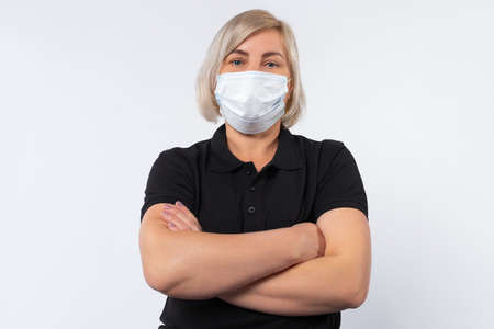 Health, safety and pandemic concept - portrait of an elderly woman wearing a protective medical mask to protect against a virus on a white background.の写真素材