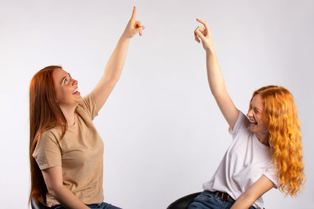 Red-haired girlfriends are having fun. Photo on a white background. High quality photoの写真素材