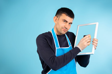 The man wipes the mirror with a sponge and looks at the camera. The concept of gender stereotypes....
