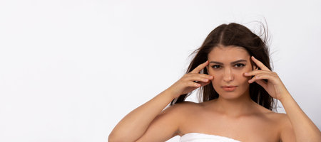 Banner. Brunette girl with a pensive look posing on a white background. Skinimalism, glowing skin...