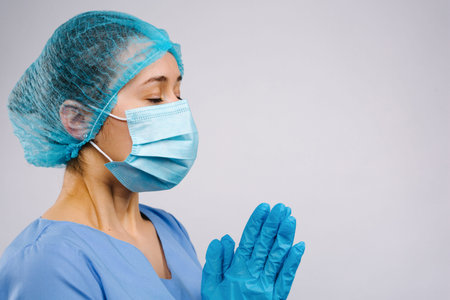 A uniformed doctor prays during the coronavirus outbreak. Emotional stress of an overworked doctor...