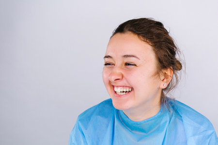 Happy nurse laughs and rejoices on white background with blank side space. Defeating the virus. High quality photoの写真素材