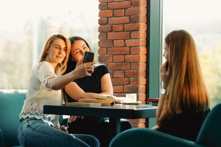 Young women make selfie on a smartphone during a coffee break.の写真素材