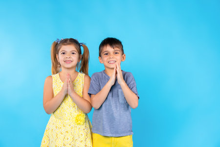 Smiling preschool children cute posing on blue background with empty side space.の写真素材