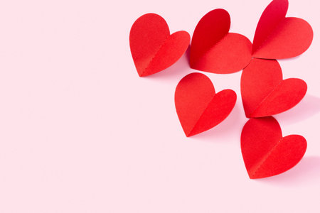 Valentines Day. Paper hearts on a pink background with empty space for your ad.