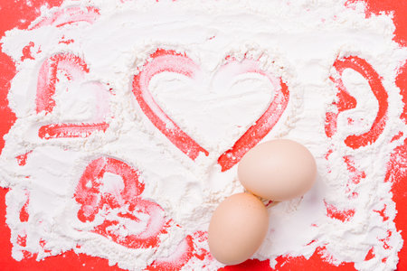 Sweet breakfast for a loved one. Hearts made from wheat flour on red backgroundの写真素材