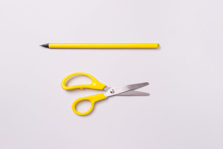 Scissors and pencil on a white background. Materials for preparation for decoration for the holiday.の写真素材