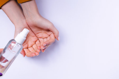 Hand protection against bacteria. Female hands and antiseptic spray on a white background.の写真素材