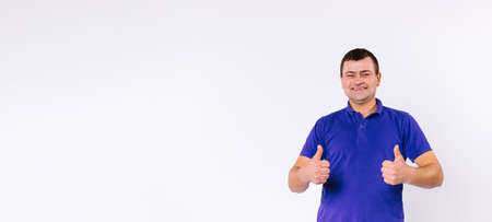 Banner,long format. A deaf-mute man with a happy smile looks at the camera and shows like. Thumbs up on a white background with side space.の写真素材