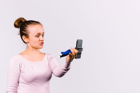 The blogger makes faces and communicates online with her subscribers. Smartphone and selfie stick....