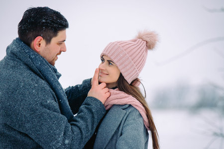 Couple has fun and laughs. Young couple playing in winter park. Winter love story, a beautiful...