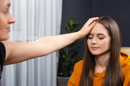 Psychotherapist supporting her depressed female patient. Close up photo, indoor officeの写真素材