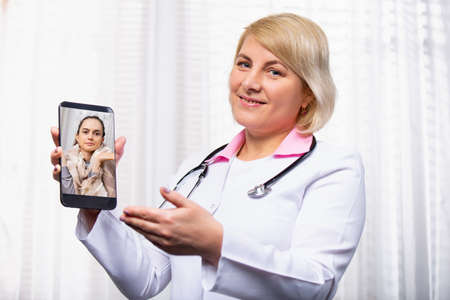 Photo showing Online Doctor working at laptop in medical office. Distance job. Business photo, modern healthcare practitioners, deliver medical services over the internet. High quality photoの写真素材