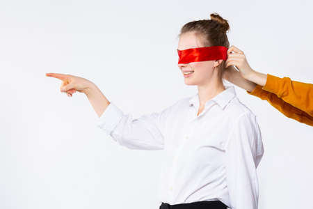 Photo of smiling blonde student, finished university, view future career job with closed eyes. Female pointing forefinger to empty side space, isolated white background. High quality photoの写真素材