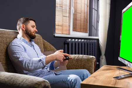 Young man playing soccer video game on console, television, in office. Work break, leisure time....