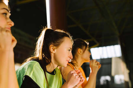 A side photo of three teammates, restless and focused, holding their fists for their teams victory. Strength and support concept.の写真素材
