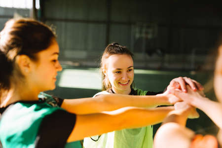 Great satisfaction after good game. Players relaxing on court having a conversation after game. Diversity and multi ethnic people in sports team. Coach gives instructions to football team. Team screamの写真素材