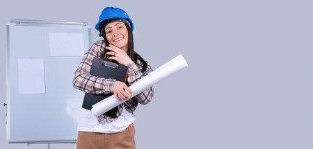 A business woman in a helmet with documents and a project in her hands solves business matters by...