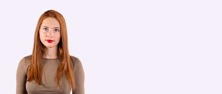 Banner, long format, light gray background with empty side space for info. Beauty portrait of sexy redhaired woman, red lips. Long Hair. Holiday Makeup. Smoky eyes and red lipstick. Glamour girl.の写真素材