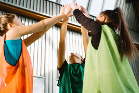 Healthy caucasian women. People, young women making high five gesture indoor after workout In a room with window with natural light. Smiling successful fitness class after training. High quality photoの写真素材