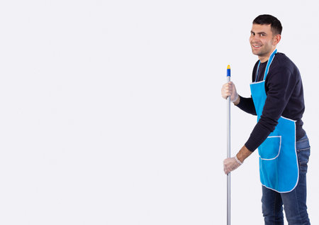 Family cleaning house. Father cleaning living room. Housework. Cleaning service. Man and dirty floor or regular household working on gray background with empty side space for ad text info.の写真素材