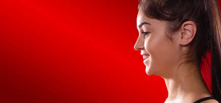 Banner, long format. Profile photo of a smiling athletic brunette girl with a long hair resting after training. High quality photoの写真素材