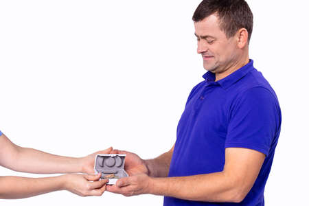 Otolaryngologist giving hearing aid to a patient in a blue t-shirt due to hearing loss and he takes it. . High quality photoの写真素材