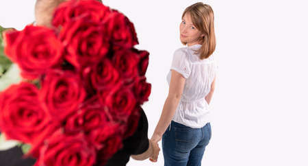 The man wants to give a bouquet of red roses to her girlfriend with beautiful face on the occasion of the engagement.の写真素材