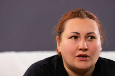 Close up photo of a woman addicted to see negative information or bad movie so she can not think about anything else.の写真素材