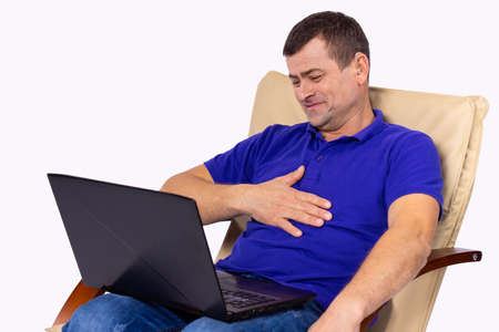 Sitting man on a chair with hearing problems put on a hearing aid, so now he speaks easily online using the computer.の写真素材