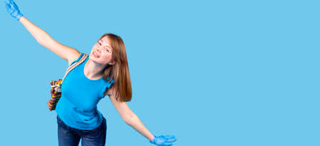 Beautiful nice young woman wearing medical gloves posing with keeping hands on the sides showing air plane flight.の写真素材