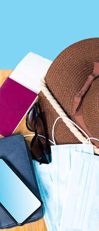 The photo top view of all necessary things people need for travelling abroad is a summer hat , sunglasses, mask and passport.の写真素材