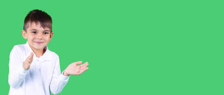 A boy in white t-shirt smiling stretch his hands forward tries to clap or to catch an object.の写真素材