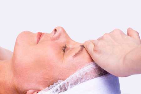 Close up photo of a woman face being in the spa salon undergoes a facial rejuvenation procedure and massage.の写真素材