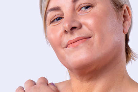 Close up photo of a blonde woman happy looking great after visiting to a beauty salon for a facial rejuvenation procedure.の写真素材