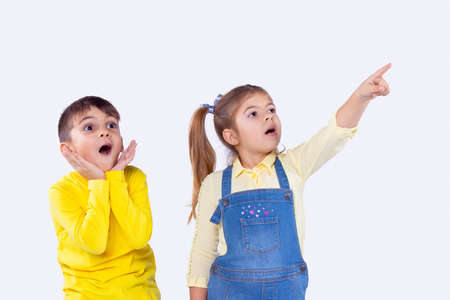 Cheerful girl and boy being excited staring up pointing to something incredible they see.の写真素材