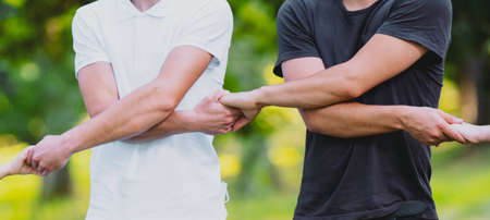 People wearing black and white t-shirts holding hands together making a circle outdoors in support of our planet, protest to save planet earth and protect it.の写真素材