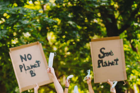 Closeup view of a homemade signs, saying there is no planet b, held by eco-activists during a march against climate change and keeping medical mask in their hands on pandemic time.の写真素材