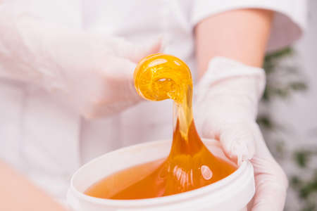 Close up photo of a sugar paste for depilation hair removal procedure, the concept of depilation, epilation, waxing, sugaring.の写真素材