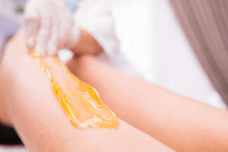 Cropped photo of waxing epilation procedure for removing hair with sugaring paste in the beauty salon, spa center beauty and body care concept.の写真素材