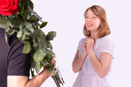 Close up photo of a blonde woman surprised and feels joy at a gift from the courier man delivered to her beautiful bouquet of roses.の写真素材