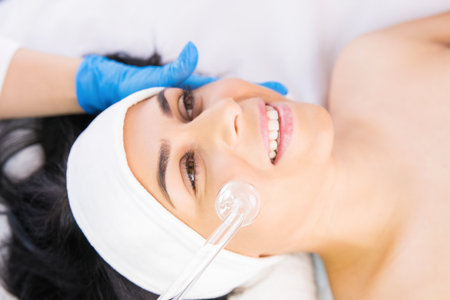 The cosmetologist makes the procedure for peeling of the face skin of a beautiful woman in a beauty salon, cosmetology and professional skin care.の写真素材